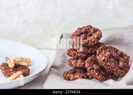 Ein Stapel von Haferflocken und Banana Schokolade Chips mit einigen Wandnüsse auf einem Leinentuch Stockfoto
