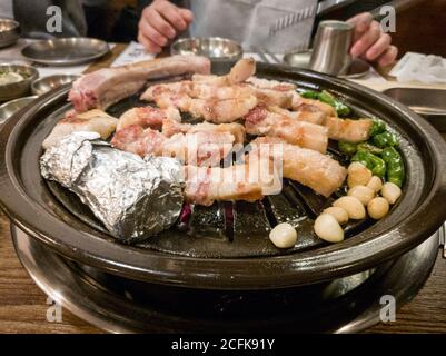 Samgyeopsal, gegrillter Schweinebauch beliebt in Korea. Drei Schicht Fleisch, Streifen von Fleisch und Fett im Schweinebauch. Gegrillt mit Knoblauch und Pfeffer. Stockfoto