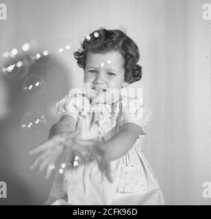 Jahrgang 1950 Foto, professionell gestellt, drei Jahre alten Mädchen in Rüschenkleid, USA Stockfoto