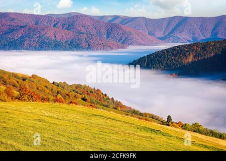 Morgen ländliche Landschaft in den Bergen. Schöne Landschaft im Herbst Saison. Fernen Tal voller Nebel. Hell sonnigen Morgen Stockfoto