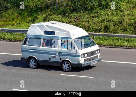 1983 80er Jahre WEISSER vw Volkswagen HIGH-TOP-VAN; Wohnwagen und Wohnmobile, Wohnmobil auf britischen Straßen, Wohnmobil Freizeitfahrzeug, Familienurlaub, Caravanette Urlaub, Touring Caravan Urlaub, van Umbauten, Vanagon autohome, Leben auf der Straße, Stockfoto