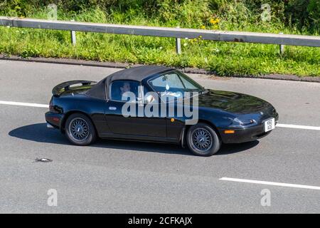 1992 90er Jahre schwarze Mazda MX-5 MX5 K60AGE; Vehicular Traffic Moving Vehicles, Autos, die Fahrzeuge auf britischen Straßen fahren, 90er-Motoren, Fahren auf dem Autobahnnetz M6. Stockfoto