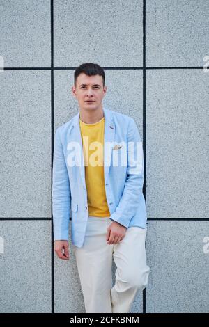 Junger Mann auf der Straße lehnte sich an der Wand und schaute Bei der Kamera Stockfoto