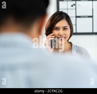 Geschäftsfrau arbeitet und einen Anruf in Home Office mit sozialen Abstand mit Bildschirmpartition, um von Coronavirus COVID-19 Verbreitung zu verhindern. Neu Stockfoto