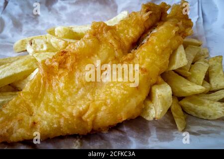 Die britische Kulturküche Fish and Chips wird in der in Papier verpackten Chips-Werkstatt serviert. Stockfoto