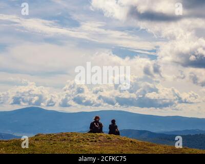 2020-08-23 Borschawa, Ukraine. Touristisches Paar liegt auf der Bergspitze mit Aussicht. Urlaub in den Bergen Stockfoto