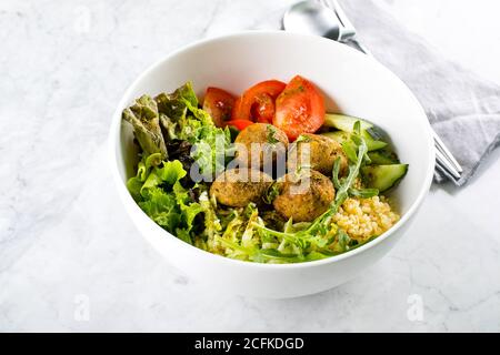 Falafel und frisches Gemüse gemischter Salat auf weißem Marmortisch Hintergrund, Draufsicht. Vegetarisch, Diät-Food-Konzept Stockfoto