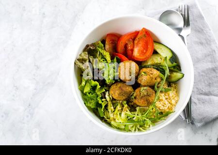 Falafel und frisches Gemüse gemischter Salat auf weißem Marmortisch Hintergrund, Draufsicht. Vegetarisch, Diät-Food-Konzept Stockfoto