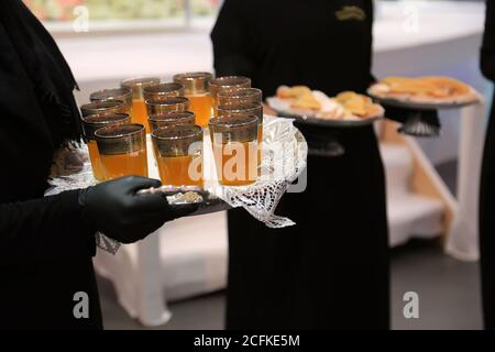 Marokkanischer Tee. Ein Mädchen hält ein Tablett voller Teetassen Stockfoto