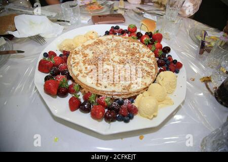 Close-up leckere Pfannkuchen mit frischen Heidelbeeren, Erdbeeren und Ahornsirup auf einem hellen Hintergrund. Mit kopieren. Süßes Ahornsirup fließt aus Stockfoto