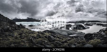 Svínafellsjökull Gletscherzungenpanorama mit Gletscherlagune und dramatischen Wolken Und Berge Stockfoto