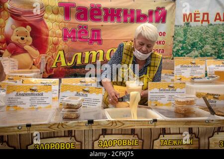 Moskau, Russland. 6. September 2020 Honigverkauf auf der Honigmesse im Moskauer Kolomenskoye Museum für Geschichte und Naturreservat, Russland.EIN Banner auf dem Hintergrund lautet "Altai Taiga Honig" Stockfoto