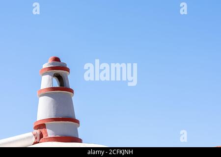 Weißer und orangefarbener Kamin auf dem Dach eines Hauses An der Mittelmeerküste von Andalusien Stockfoto