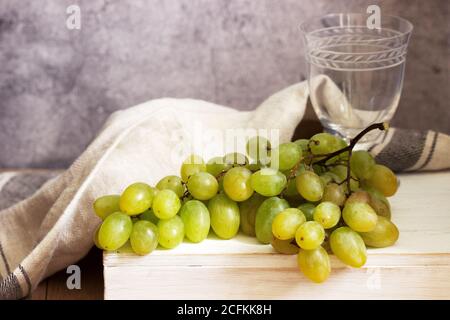 Bernsteinfarbenes Traubenbündel auf grauem Betongrund. Stockfoto