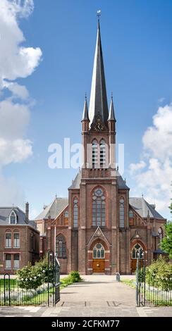 Wateringen, Niederlande, 23. August 2020: Die neugotische römisch-katholische Kirche des heiligen Johannes des Täufers gegen einen blauen Himmel Stockfoto