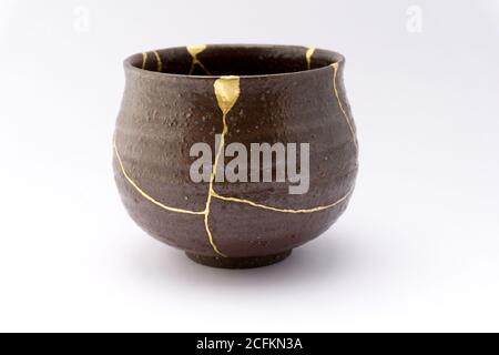 Kintsugi schwarzer Tee Zeremonie Schüssel. Gold Risse Restaurierung auf alten japanischen Keramik. Stockfoto