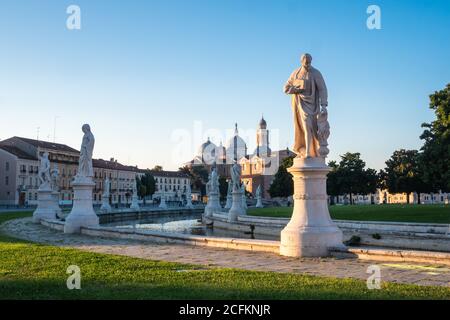 Prato della Valle Hauptplatz in Padua, Venetien, Italien bei Sonnenaufgang am frühen Morgen mit Statuen und der Abtei o Santa Giustina Stockfoto