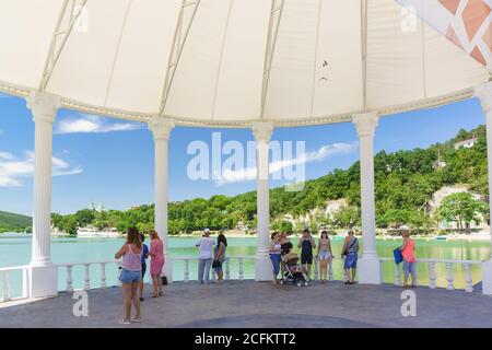 Russland, Region Krasnodar, Novorossijsk, Abrau-Durso Dorf - 12. Juni 2018: Urlauber auf der Promenade des malerischen Bergsees Abrau auf einem Stockfoto