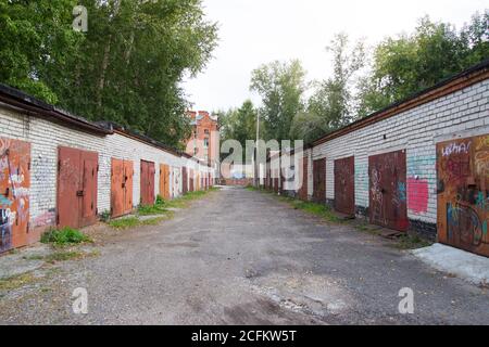 Garagen in Russland. Garage Komplex für Parkplätze. Ziegelgaragen mit Metalltoren einer Garagenkooperative. Stockfoto