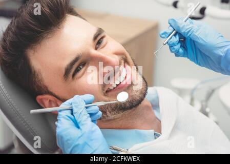 Mann, der Zähne Zahnärzte untersucht. Übersicht von Karies Vorbeugung Stockfoto