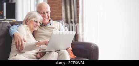 Ältere Paare, die gemeinsam im Internet surfen. Rentner nutzen soziale Medien. Web-Banner-Bild Hintergrund mit Kopierplatz Stockfoto