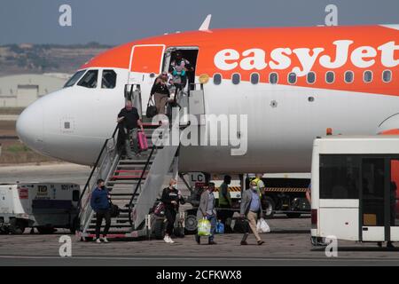 Passagiere mit Gesichtsmasken, die von einem easyJet Airbus A320neo-Jet-Flugzeug in Malta aussteigen. Auswirkungen des COVID-19-Coronavirus auf Flugreisen. Stockfoto