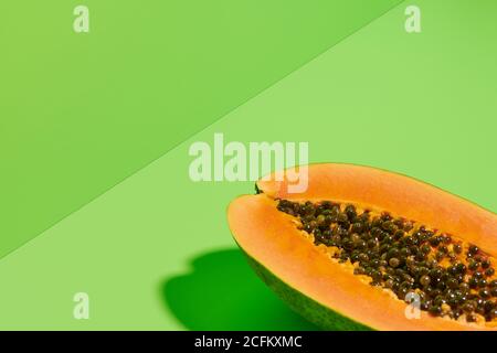 Von oben Nahaufnahme der frischen reifen halbierten Papaya mit Samen Platziert auf hellgrünem Hintergrund Stockfoto