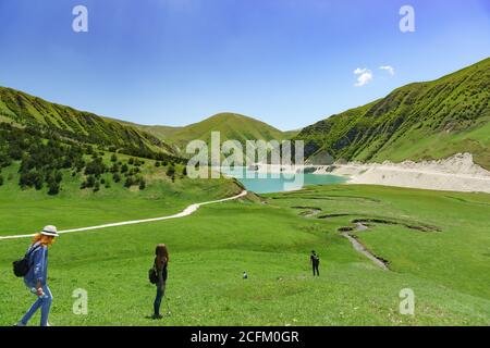 Botlikh Bezirk, Dagestan, Russland - 01. Juni 2019: Touristen steigen auf den Hochgebirgssee Kezenoi am. Üppiges Grün bedeckt die Hänge der Moun Stockfoto