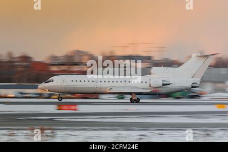 Schmaler Körper regionalen Passagierflugzeug Start bei Sonnenuntergang, Seitenansicht in Bewegung, dramatischen Himmel auf Hintergrund.Aviation Konzept Stockfoto