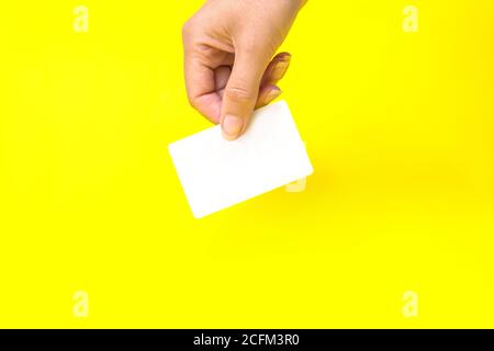 Hand mit Visitenkarte, Mockup, auf gelbem Hintergrund Stockfoto