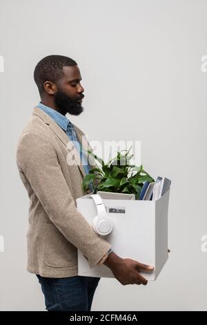 Junger Büroangestellter mit Kopfhörer, Grünanlage und anderen Vorräten Stockfoto