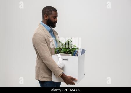 Seitenansicht des bärtigen afroamerikanischen Büromanagers mit der Box Verbrauchsmaterialien Stockfoto