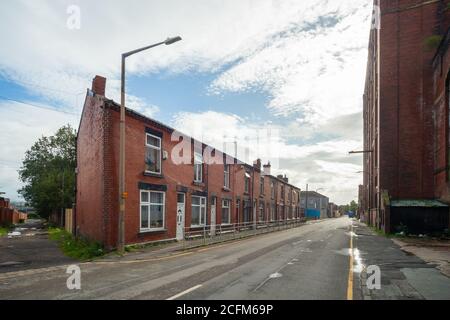 Cawdor Street, Farnworth. Terrassenhäuser aus roten Backsteinen. Die Textilfabrik Bolton Nummer 2 befindet sich auf der rechten Seite. Cotton Mill wurde Anfang 1900er erbaut, möglicherweise 1905. UK. Stockfoto