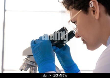 Kopf und Handschuhen der jungen Wissenschaftlerin, die Chemie studiert Reaktion Stockfoto