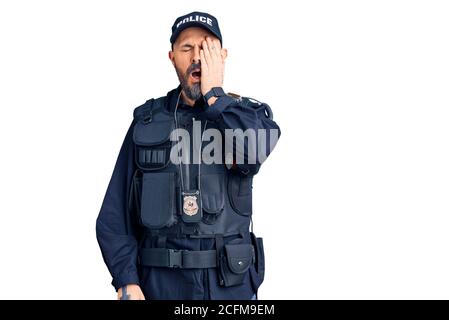 Junger gutaussehender Mann mit Polizeiuniform gähnend müde Abdeckung halb Gesicht, Auge und Mund mit Hand. Gesicht schmerzt in Schmerzen. Stockfoto