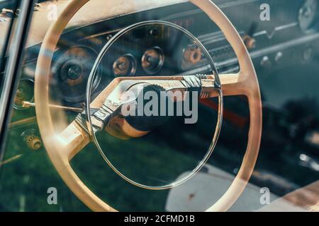 Lenkrad von alten verlassenen rostigen Auto, Blick durch Glas mit Spiegelung. Stockfoto