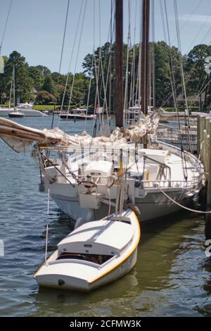 Ein Chesapeake Bay-Skippjack ist vor dem Schubboot zu sehen, eine Energiequelle, die von einem großen Motor in der Mitte des kleinen Schiffes im hinteren Teil bereitgestellt wird. Stockfoto