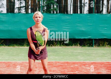 Professionelle Tennisspielerin Frau in bereit Position konzentriert. Eine Sportlerin wartet auf Dienst. Herausforderung und Konzentration im Wettbewerb. Stockfoto