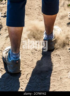 Nahaufnahme von Stiefeln; weibliche Wandererin, die durch sehr feine Asche geht; Decker Forest Fire; Central Colorado; USA Stockfoto