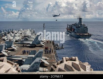 200905-N-DL524-1046 PHILIPPINE SEA (SEPT 5, 2020) der einzige Vorwärtsflugträger der Marine USS Ronald Reagan (CVN 76) nähert sich Flottennachfüller USNS John Ericsson (T-AO 194) als MH-60S Seahawk an, angeschlossen an die Golden Falcons of Helicopter Sea Combat Squadron (HSC) 12, transportiert Fracht während einer Nachschub-auf See. Ronald Reagan, das Flaggschiff der Carrier Strike Group 5, bietet eine kampfbereite Kraft, die die Vereinigten Staaten schützt und verteidigt, sowie die kollektiven maritimen Interessen ihrer Verbündeten und Partner in der Indo-Pazifik-Region. (USA Navy Foto von Mass Commu Stockfoto