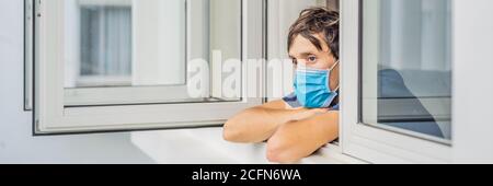 BANNER, LANGFORMAT extrem müde junger Mann aus dem Fenster schauen, zu Hause allein. Selbstisolation zu Hause, Quarantäne aufgrund Pandemie COVID 19. Mental Stockfoto