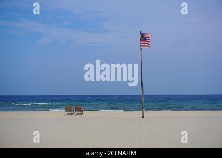 Malaysische Flagge winkt am Strand der Tioman Insel während des heißen Nachmittagstages. Stockfoto