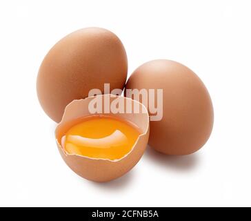 Ein Ei auf weißem Hintergrund und ein zerbrochenes Ei wurden aus einem Winkel fotografiert. Stockfoto