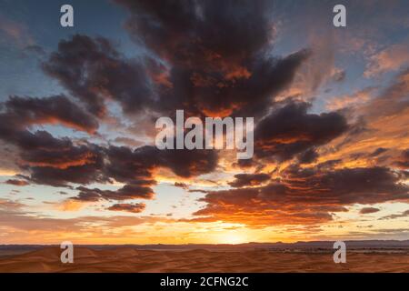 Fantastische helle und bunte Sonnenuntergang über Sanddünen in Sahara Wüste in Marokko. Erstaunliche Wolken und Sonnenlicht. Stockfoto