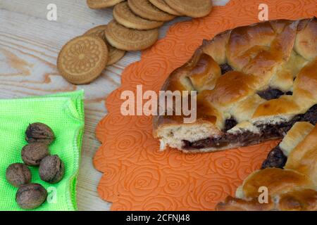 Hausmannskost, Apfelmarmelkuchen, Kirschen und Walnüsse, Kekse und Walnüsse auf einer grünen Serviette auf dem Tisch Stockfoto