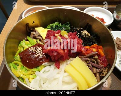 Jeonju Bibimbap, eine Schüssel mit warmem weißen Reis mit gewürztem Gemüse und Gochujang, Chili-Pfeffer-Paste gekrönt. Rindfleisch Tartare auf der Mitte gekrönt. Stockfoto