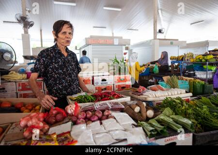 Bandar Seri Begawan / Brunei - 16. Januar 2019: Mann, der Gemüse an einem Stand auf dem lokalen Markt verkauft Stockfoto