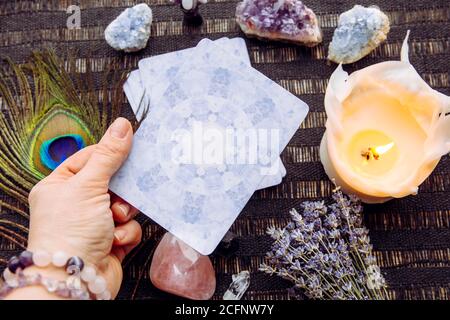 Deck mit Weissagung hausgemachte Engelskarten auf schwarzem Tisch, umgeben von Halbedelsteinen Kristallen. Selektiver Fokus auf Amethyst Kristallengel. Stockfoto