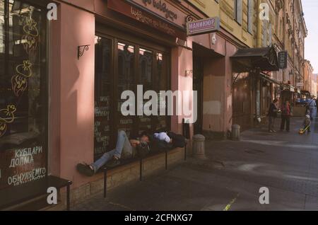 Sankt Petersburg, Russland - 21. August 2020: Obdachlose schlafen auf einer Bank an einem öffentlichen Ort während covid-19 Stockfoto