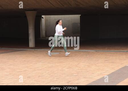 Kurvige kaukasische Frau, die in einer Stadt trainiert Stockfoto